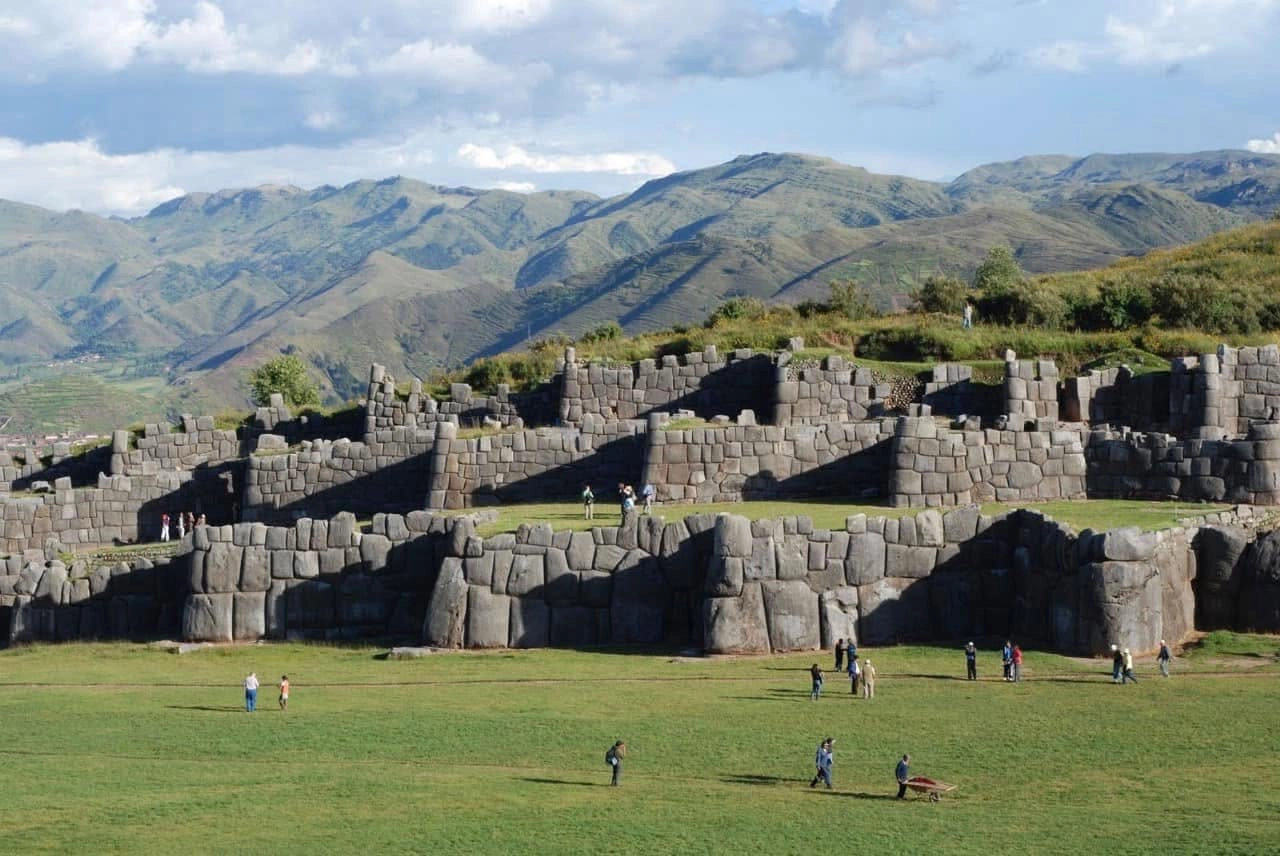 Turistas disfrutando la ciudad del Cusco, destino ideal para construir una casa de campo en Perú